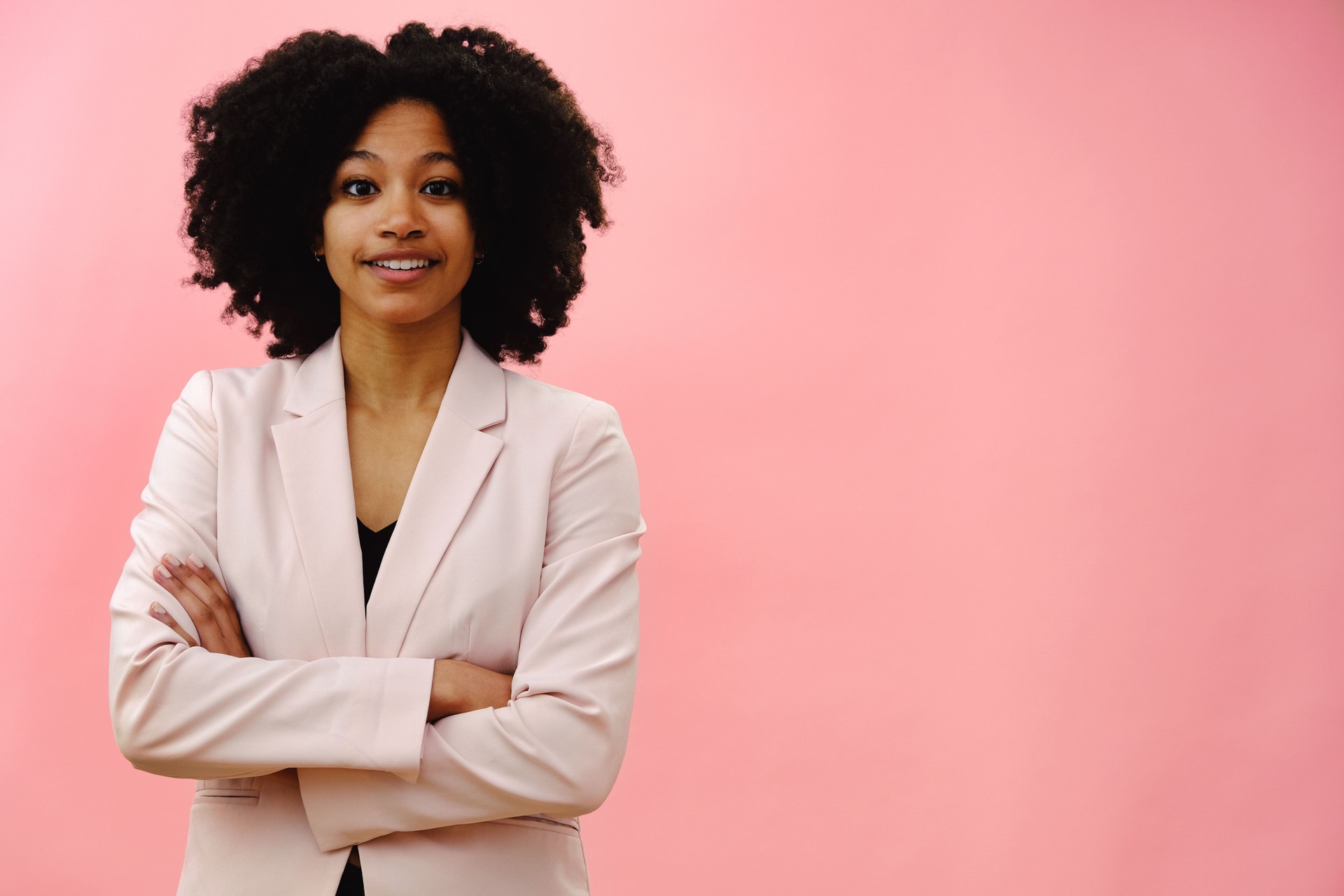 Woman wearing pink jacket with arms folded